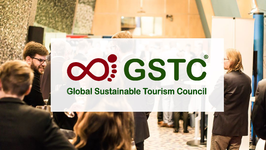 Global Sustainable Tourism Council logo over a photo of professionals gathered at an event